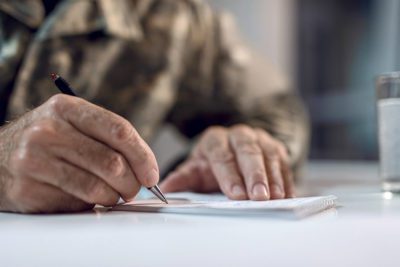 anciano escribiendo en documento