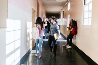 alumnos caminando por pasillo de escuela