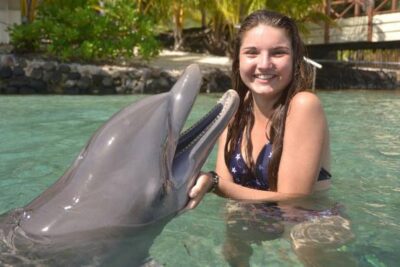 mujer acariciando delfin en miami florida