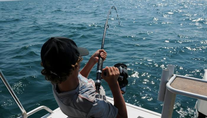 hombre pescando con bara desde un bote en miami