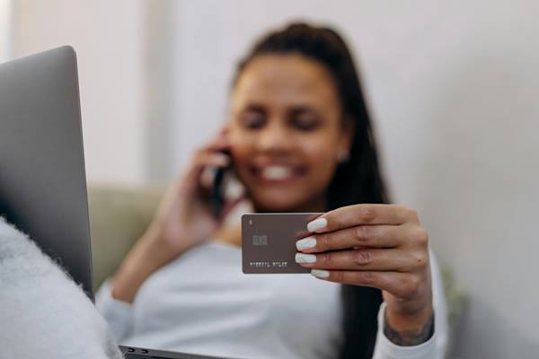 mujer sosteniendo su primera tarjeta de credito