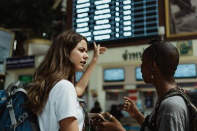 amigas mirando informacion en pantallas de un aeropuerto