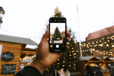 hombre tomando foto a gran arbol de navidad