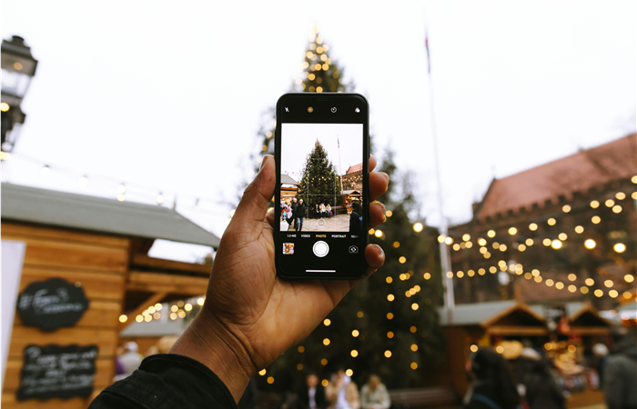 hombre tomando foto a gran arbol de navidad